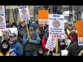 Warmly dressed people march with LIUNA and IBEW union signs opposing "Right to work for less" in Wisconsin.