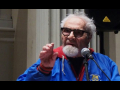 Herman Benson at podium in blue jacket with arm raised