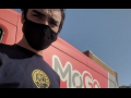 A bikeshare driver wearing a black mask stands in front of a red MoGo van.