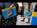 Several woman hold blue and yellow signs that read "Pass the Pro Act: Build Back Better with Unions."