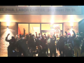 A group of people stands outside the St. Paul Labor Center, fists raised. It is dark out, and they are backlit.