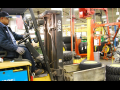 A worker drives a forklift inside a John Deere plant