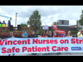 People outside hold a huge banner: "St. Vincent Nurses on Strike for Safe Patient Care; MNA"