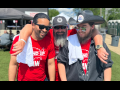 Three guys in red Stand-Up Strike (UAW) t-shirts, two bearded, stand outside on grass with arms around each other’s shoulders, smiling big.