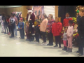 Kids stand in a row, with Santa among them, inside the union hall at a Christmas function