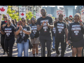 A group of autoworkers with black “Protect Our Freedom to Vote” shirts march