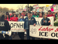 People march in the street carrying various banners and signs. The most visible banners says "Labor says ICE out." Others partially visible are for two Oregon health care unions, OFNHP and ONA. Their red and green shirts (respectively) are also visible, and someone has a blue AFT shirt. Many handmade picket signs are visible, including "We are all Alex," "Unions want ICE out," "Hold ICE accountable," and "Ge(stop)o the bullshit" 