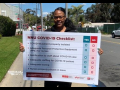 A nurse holds a sign showing "NNU COVID-19 Checklist: patient properly isolated, adequate PPE for nurses, notification to staff about case, adequate staffing for patient, adequate testing, nurses properly placed on leave"