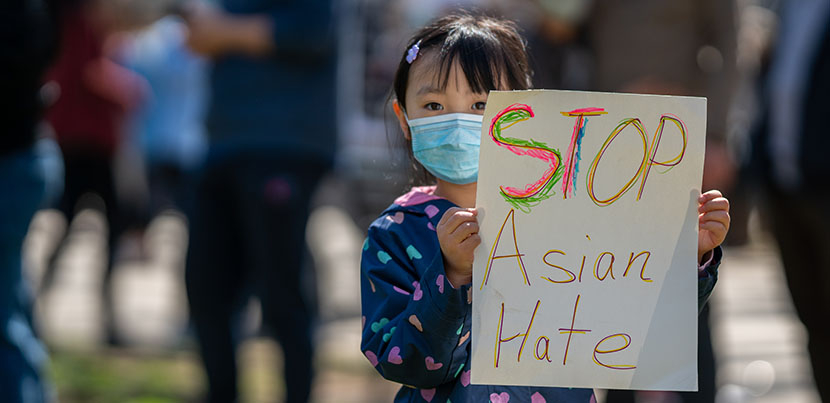 Little girl holding sign reading "Stop Asian Hate."