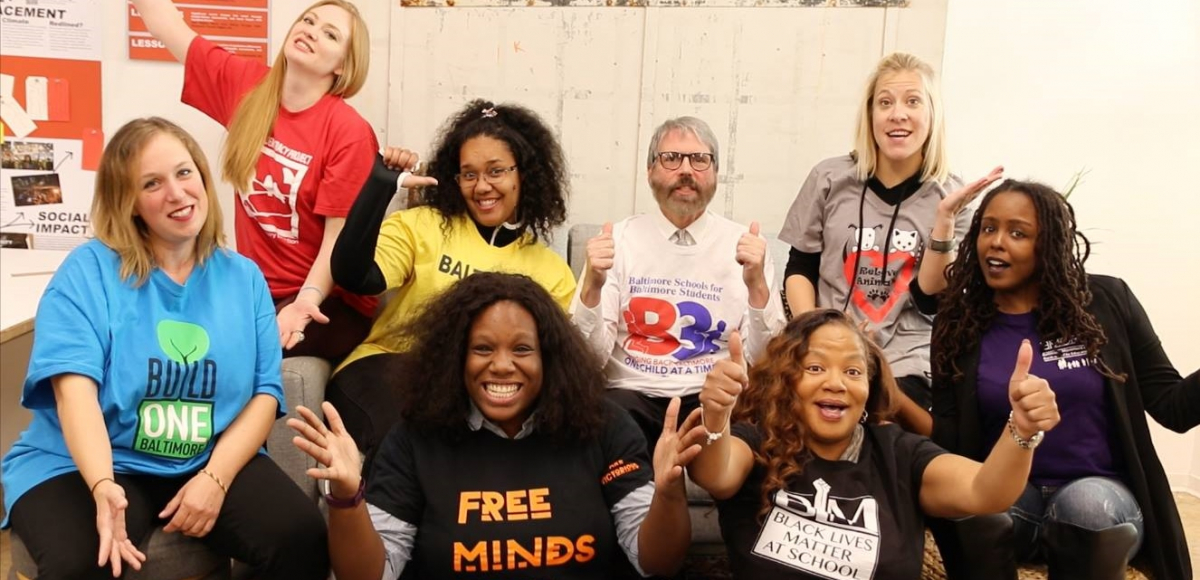 Eight teacher leaders from the Unions We Deserve slate pose together, smiling and giving thumbs-up. T-shirt slogans include "flree minds," "Black lives matter at school," "Baltimore schools for Baltimore students," and "build one Baltimore"