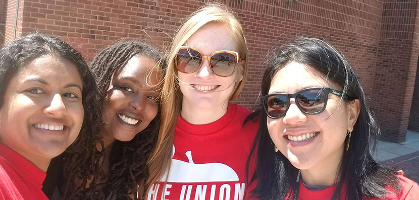 Selfie of four Baltimore teachers in front of a school.