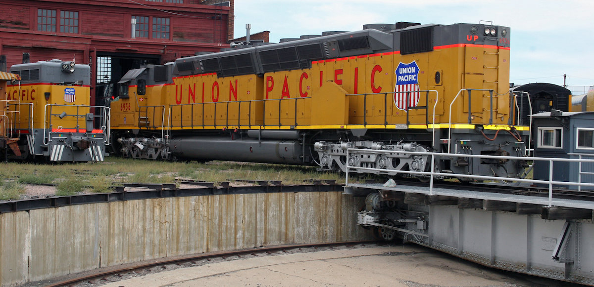 An orange Union Pacific railroad locomotive is shown in a repair area.