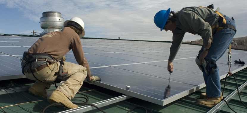 Two workers installing solar energy at Garfield County Fairgrounds