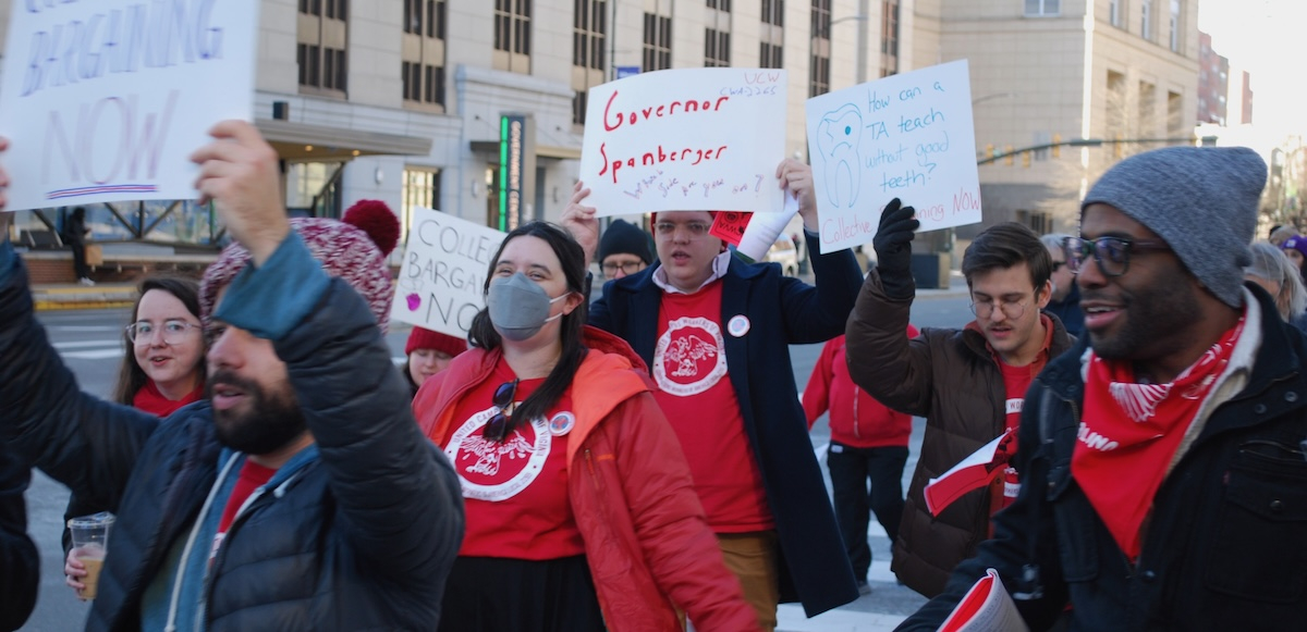 A crowd marches with signs