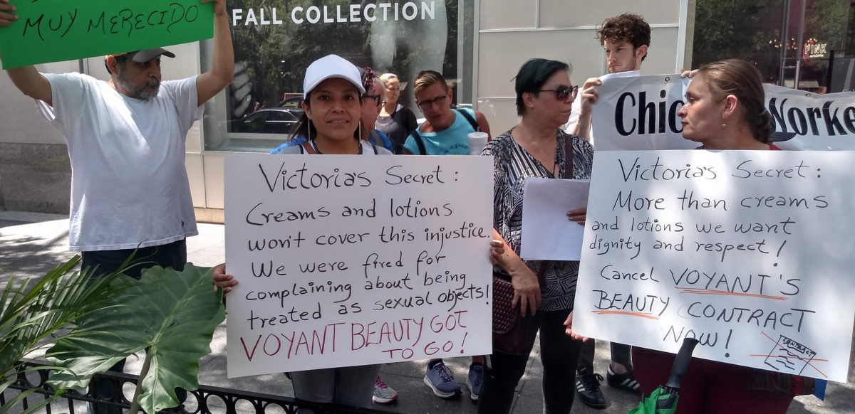 Voyant Beauty workers demonstrate in front of a Victoria's Secret store in Chicago, holding signs that read: "Victoria's Secret: Creams and lotions won't cover this injustice. We were fired for complaining about being treated as sexual objects! Voyant Beauty has got to go!" and "Victoria's Secret: More than creams and lotions we want dignity and respect! Cancel Voyant Beauty's contract now!"