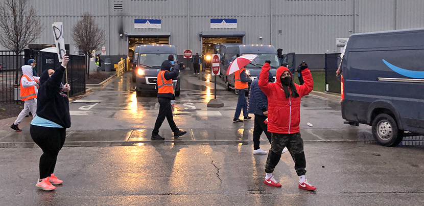 Amazon workers picketing in the parking lot of their warehouse.