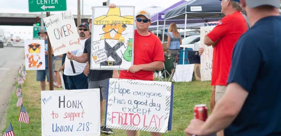 Frito-Lay workers hold signs on the picket line.