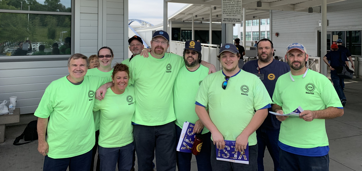 Group of workers in matching green T-shirts outside the plant