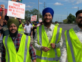 Members of the Naujawan Support Network march holding signs that say "This employer is a wage thief."