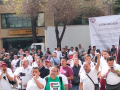 Workers gather with fists in the air and the union's flag flying behind them. 