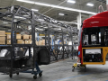 The skeleton of an unfinished bus, and the outer shell of another are shown in a factory