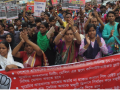 Bangladeshi workers rally behind a banner