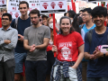 a group of 15 smiles, applauds, and holds signs saying “MIT works because WE do”