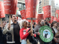 A crowd raise huge red cups that say “Baristas on Strike”