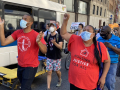 Marchers wearing masks walk through the streets of New York City, with Jabari Brisport and Marcela Mitaynes in the front.