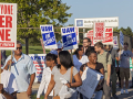 Group of UAW strkers picketing with signs against tiered wages.