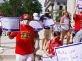 Teachers wearing masks hold signs that say Make Our Schools Safe and Not Until It's Safe.