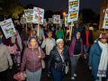 East African workers carrying signs march in the dark during the strike.