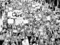 Black-and-white photo of huge crowd of Chicago teachers marching through a downtown street. Many carry signs. One large banner says "CORE," which stands for the Caucus of Rank-and-File Educators.