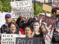 Marchers with signs including "IBEW Against Oppression" and "No KKKops"