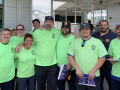 Group of workers in matching green T-shirts outside the plant