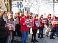 A crowd holding signs saying Support Somerville Educators and Living Wage for Paras