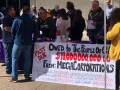 Supporters of Prop 15 tabling for the measure with a big sign.