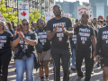 A group of autoworkers with black “Protect Our Freedom to Vote” shirts march