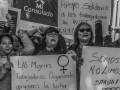 Workers hold signs in Spanish saying ‘we are workers not beggars’.