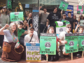 Youngish workers pose with raised fists on a city street. Printed green signs say "OPEIU Local 153, Kickstarter United, On strike," One handwritten sign says "Protect the 4DWW"